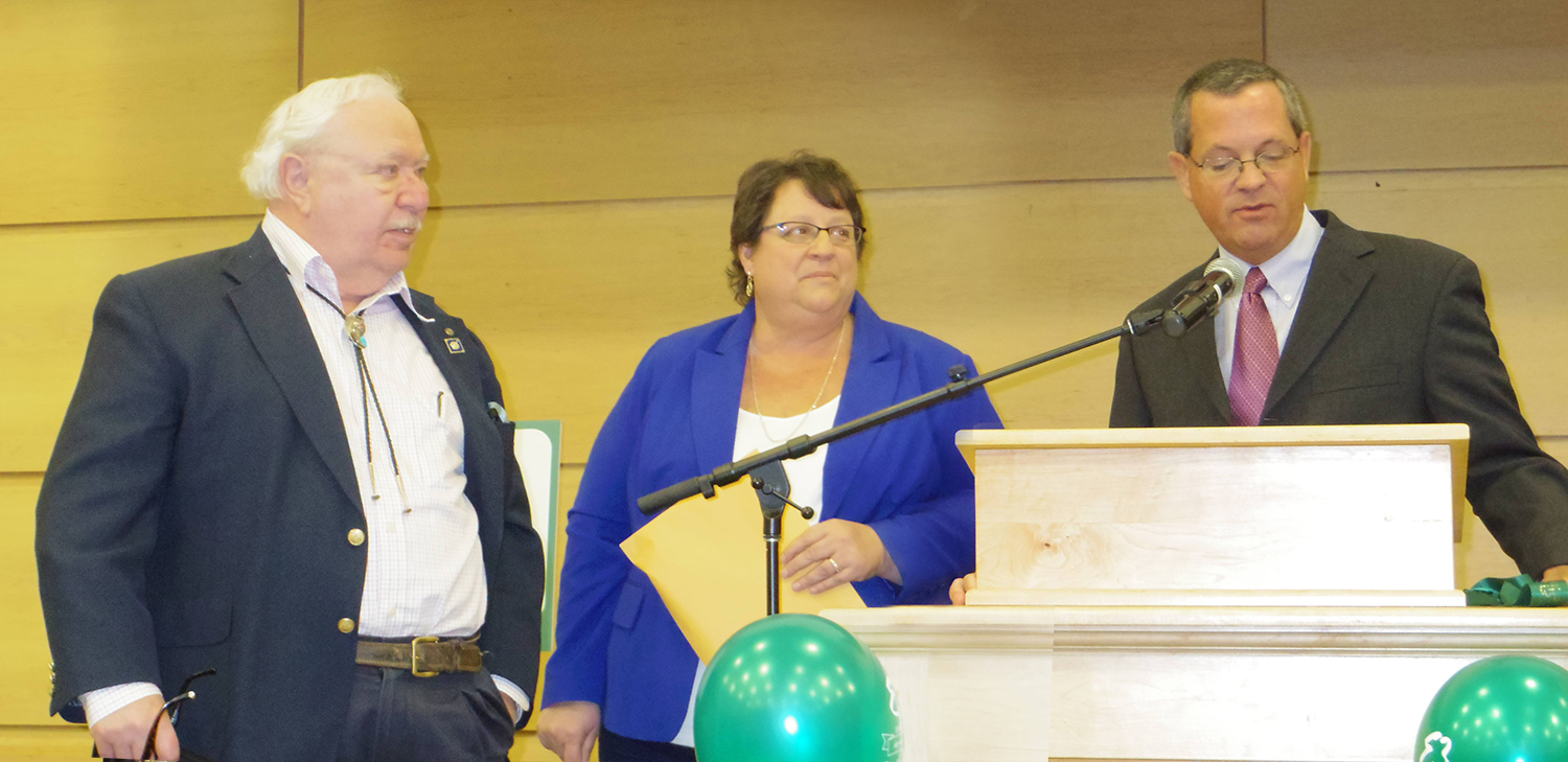 Arny, Linda, and Dennis standing at podium