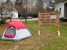 Tent outside next to a National Hunger and Homeless Awareness Week sign