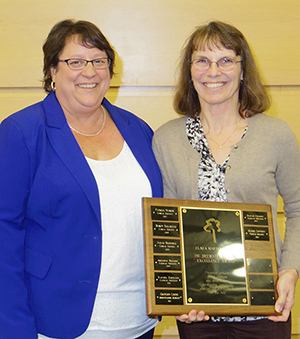 Linda standing with Joy holding the Brewster Martin Excellence Award