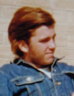 Portrait of Christoper Anthony Vezzetti, a red-haired young man with a slight beard and a blue denim jean jacket